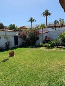 une cour avec une maison blanche dotée d'une clôture et de fleurs dans l'établissement Casa Janni, à Puerto de la Cruz