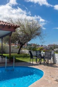 d'une terrasse avec une table et des chaises à côté de la piscine. dans l'établissement Casa Janni, à Puerto de la Cruz