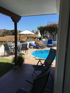 osoba siedząca na krześle obok basenu w obiekcie Casa Janni with heated private pool w Puerto de la Cruz