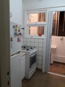 a kitchen with a stove and a refrigerator and a window at Edificio Valle in Mar del Plata