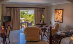 a bedroom with a bed and a table and a chair at Luxury Beach Apartments in Amanzimtoti
