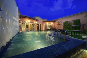 a swimming pool in front of a house at night at Goot Resorts in Riyadh