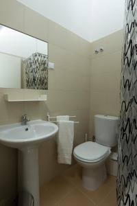 uma casa de banho com um lavatório, um WC e um espelho. em Turismo do Seculo em Estoril