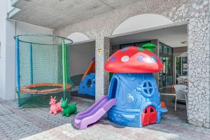 a childs play area with a playground with a mushroom at Hotel Giamaika in Cesenatico