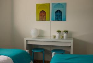 a bedroom with two stools and a table with windows at Turismo do Seculo in Estoril