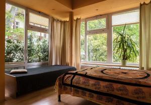 ein Schlafzimmer mit Bett und großen Fenstern in der Unterkunft Wohnen im Zentrum in Potsdam
