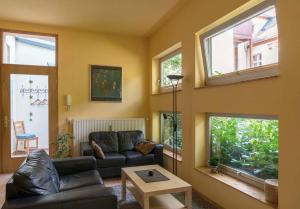 ein Wohnzimmer mit einer Couch und zwei Fenstern in der Unterkunft Wohnen im Zentrum in Potsdam