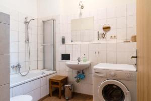 ein Badezimmer mit Waschmaschine und Waschbecken in der Unterkunft Wohnen im Zentrum in Potsdam + 10 Fotos