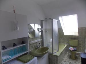 ein Badezimmer mit einem grünen Waschbecken und einer Badewanne in der Unterkunft Ferienwohnung Heese Wennigsen in Bönnigsen