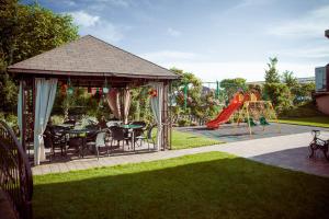 a gazebo with a table and chairs and a playground at Equinoxe Royal Reghin in Reghin