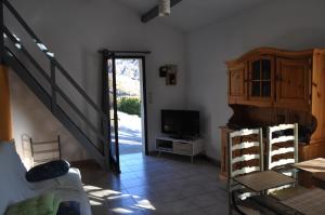 a living room with a staircase and a television at gite les iris in La Robine