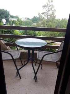 a table and two chairs on a balcony at Christos Apartments in Drousha