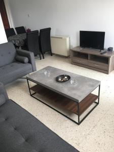 uma sala de estar com um sofá e uma mesa de centro em Christos Apartments em Dhrousha