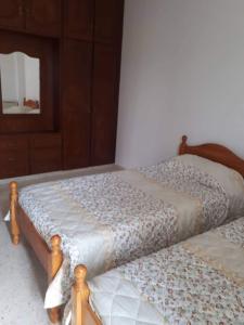 two beds sitting next to each other in a bedroom at Christos Apartments in Drousha