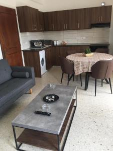 a living room with a table and a couch and a kitchen at Christos Apartments in Drousha