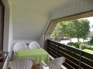 eine Veranda mit weißen Stühlen, einem Tisch und einem Fenster in der Unterkunft Ferienwohnung Heese Wennigsen in Bönnigsen