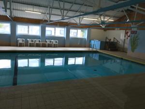 - une piscine d'eau bleue dans un bâtiment dans l'établissement Number 43 The Gower Holiday Village, à Swansea