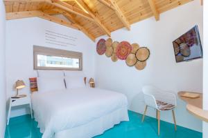 a bedroom with a white bed and a chair at Chandakos 8 Design Apts in Heraklio