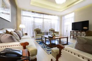 a living room with a couch and a table and a tv at Goot Resorts in Riyadh