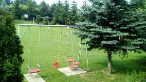une balançoire vide installée dans un parc avec un arbre dans l'établissement Resort Čokori, à Banja Luka