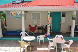 una casa con mesas y sillas y techo rojo en Mobay Kotch, en Montego Bay