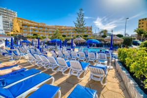 um grupo de espreguiçadeiras e guarda-sóis num resort em Ona el Marqués em Puerto de Santiago