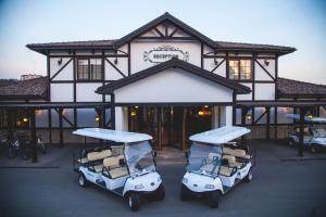 two golf carts parked in front of a building at Sakit Gol - Silent Lake Hotel in Şamaxı