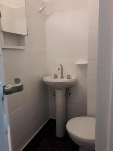 a white bathroom with a toilet and a sink at Edificio Valle in Mar del Plata