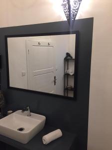 a bathroom with a mirror, sink, and toilet at Riad Dar Soufa in Rabat