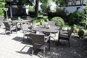 een patio met tafels en stoelen in een tuin bij Gasthof Wäscherschloss in Wäschenbeuren