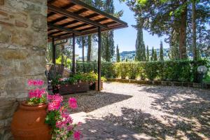 a garden with a wooden pergola and flowers at Agriturismo Filettro in Volterra