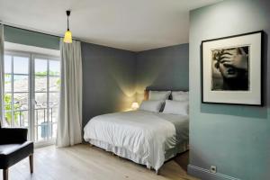a bedroom with a bed and a chair and a window at L'Oiseau Qui Chante in Eygalières +12 photos
