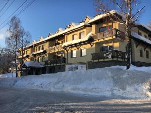 een gebouw met een berg sneeuw ervoor bij Apartment Horec Donovaly in Donovaly