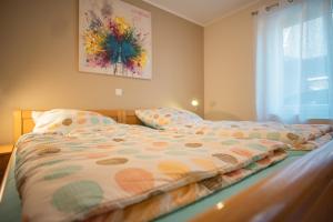 a bed with a comforter on it in a bedroom at Haus Theobald in Alpen