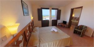 a hotel room with a bed and a window at Club Esse Gallura in Aglientu