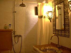 a bathroom with a sink and a shower with a mirror at Hotel Rural Cortijo La Alberca in Níjar