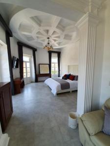 1 dormitorio grande con 1 cama y 1 sofá en Hotel Estancia Real en Tepatitlán de Morelos