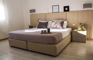 a bedroom with a large bed with a wooden headboard at Coluni Sport & Resort srl in Gravina in Puglia