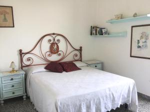 una camera con un letto bianco e due comodini di The Nest a Grosseto