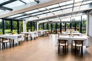 a dining room with tables and chairs and windows at Dworek Helena in Biała Podlaska
