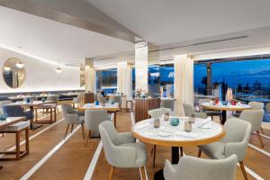 a restaurant with tables and chairs and windows at Cascade Wellness Resort in Lagos