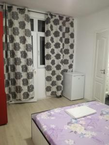 a room with a bed and curtains and a window at Yraida's house Constanta in Constanţa