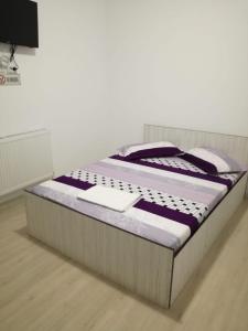 a bed sitting on a wooden floor in a room at Yraida's house Constanta in Constanţa