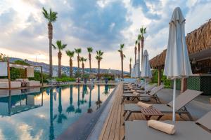 a hotel pool with lounge chairs and umbrellas at Hotel Vita Bella Resort & Spa in Gundogan