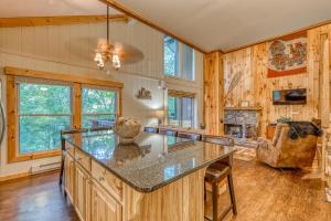 a kitchen with a large island in a room with a fireplace at Bee Branch 24 in Sugar Mountain