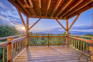 a cabin with a deck with a view at Crest 100E in Sugar Mountain