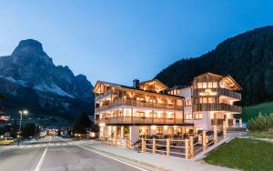 un hotel en las montañas con una montaña en Villa Tony - Small Romantic Hotel, en Corvara in Badia