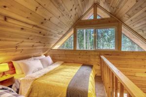 a bedroom in a log cabin with a large window at Sweet Retreat Cabin in Leavenworth