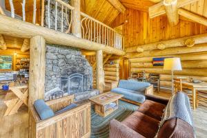 a living room with a fireplace in a log cabin at Eaglet Log Home in Franconia
