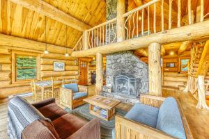 a living room with a fireplace in a log cabin at Eaglet Log Home in Franconia